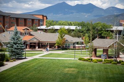 Students walking on the Flagstaff mountain campus during a sunny spring day.