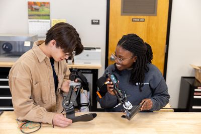 Two engineering students working on a robotics project.