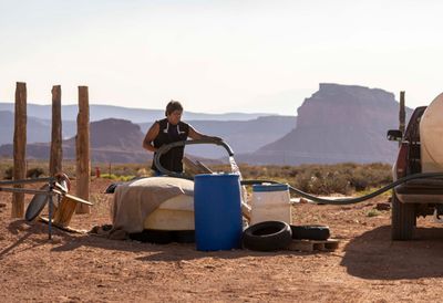 Tommy Rock, Assistant Research Professor at Northern Arizona University, fills a container with water from a livestock well in Utah.