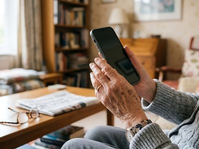Picture of an elderly person's hand holding a cell phone