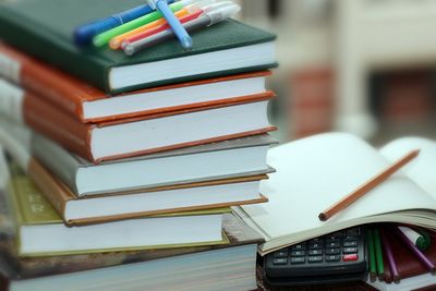 A stack of textbooks with highlighters on top