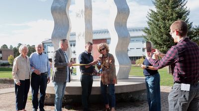 Carrie Besnette Hauser, President Cruz Rivera and other people cutting a ribbon in front of the French fries statue.