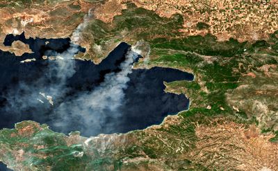 Satellite image of two billowing trails of smoke emanating from different areas around Athens